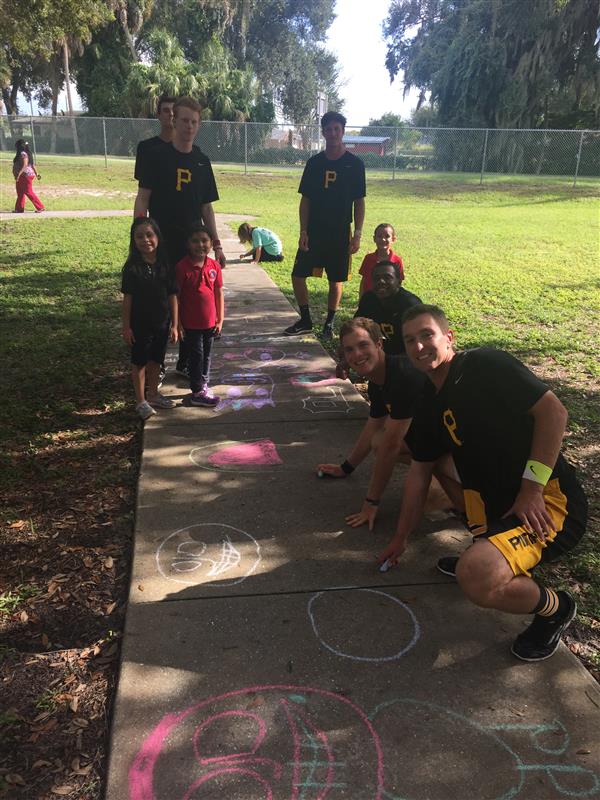 students and Pirates players draw on sidewalk with chalk